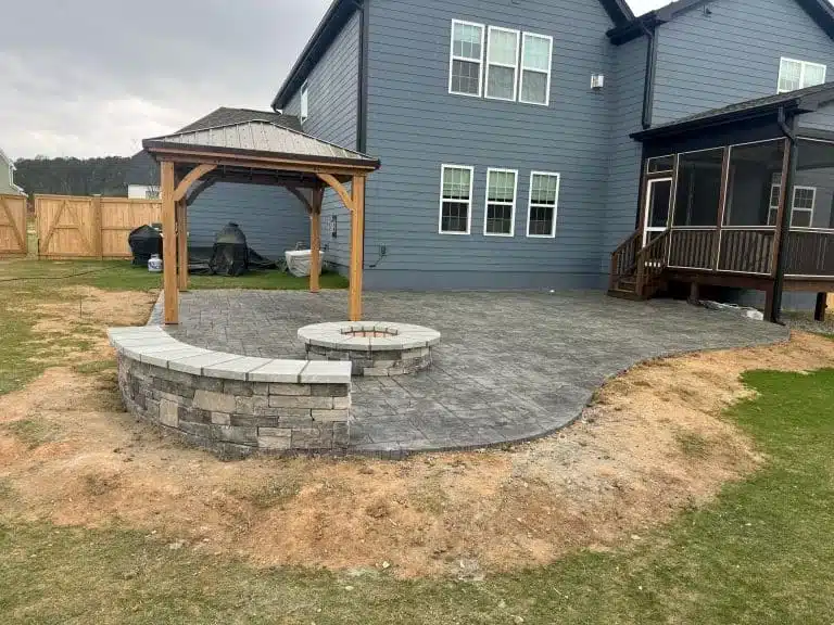 Stamped patio with a firepit, curved seating wall and wooden gazebo